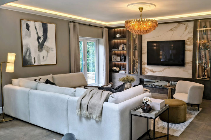 Large cream corner sofa in a contemporary living room with glass chandelier and luxurious styling.