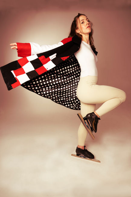 Speed Skater throwing her jacket behind her.