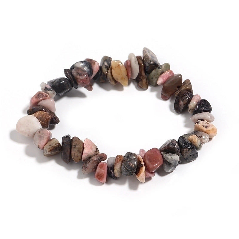 Thumbnail: Colorful gemstone bracelet made of various smooth, unevenly shaped stones in shades of pink, brown and black white background