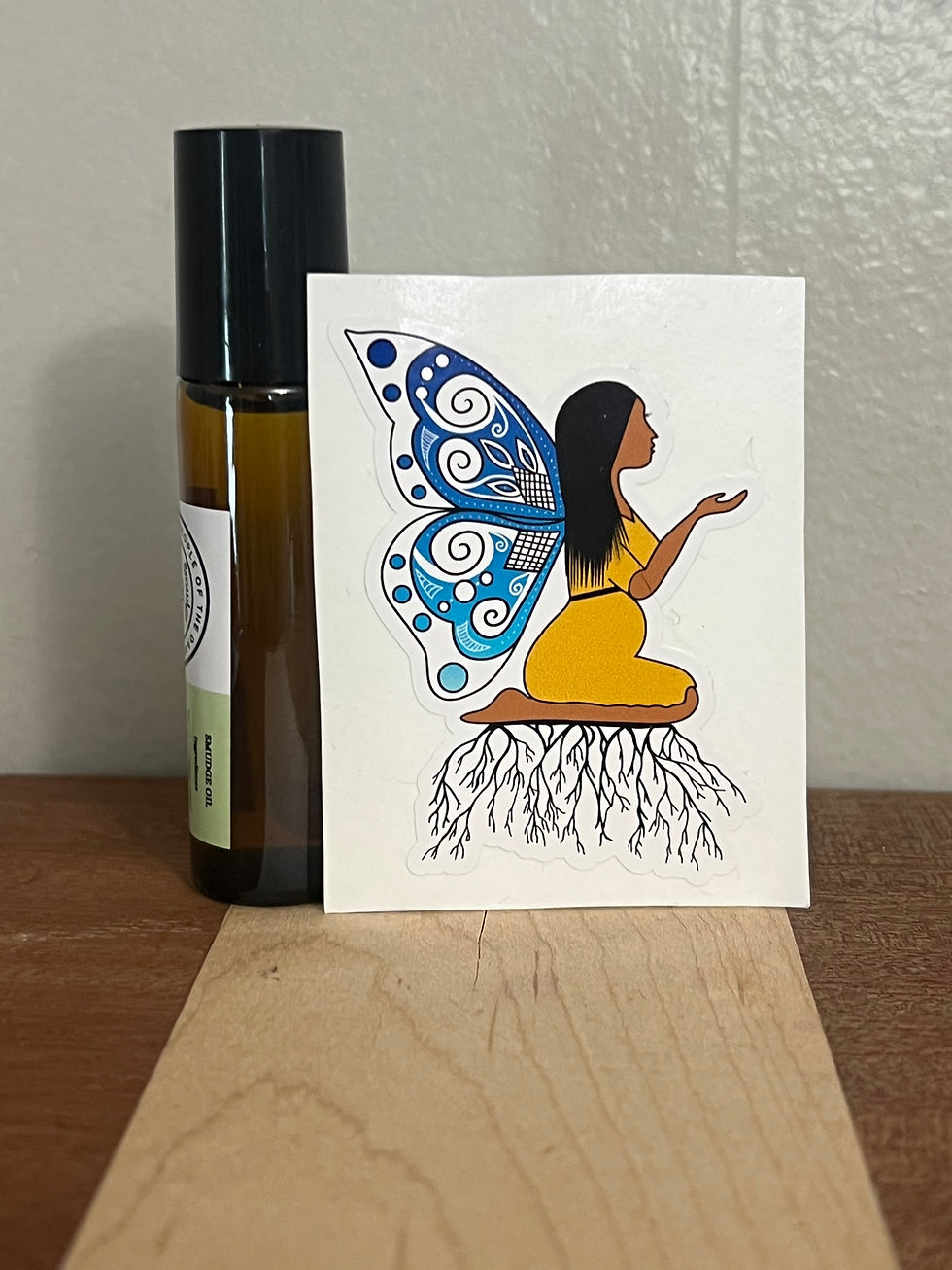 sticker showing an expectant mother with blue ombre butterfly wings and kneeling on branches