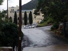 white building through trees on a rainy day