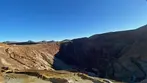 Vast terraced Lavender Pit mine with colorful rock layers and deep shadows under clear blue sky.