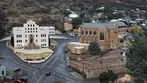 High-angle view from Quality Hill showing the prominent white Art Deco courthouse and adjacent church in Bisbee, Arizona.