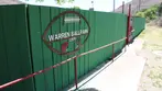 Green wooden fence at Warren Ballpark with large football-shaped sign reading Warren Ballpark 1909.