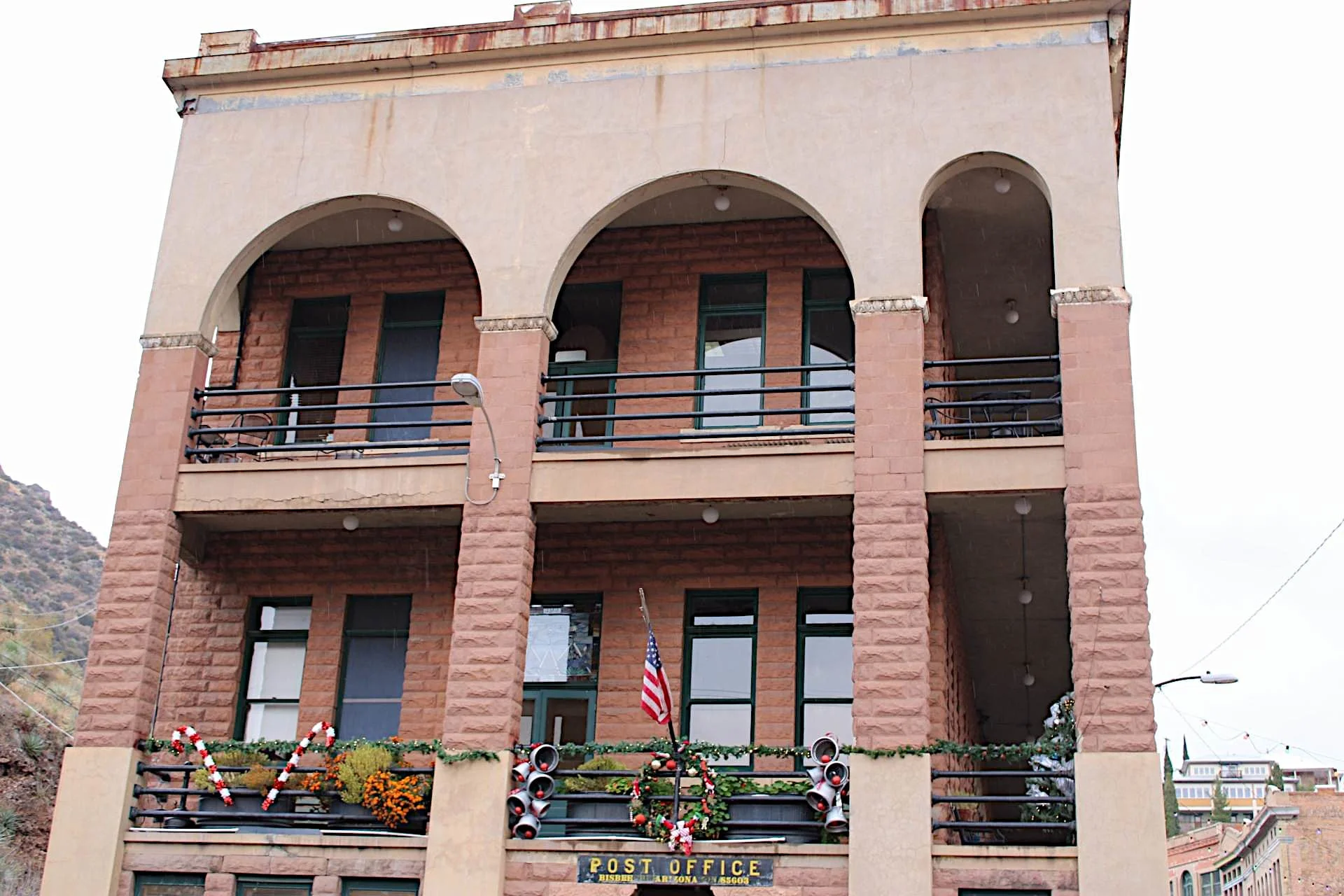 Historic Copper Queen Library and Post Office building with arched windows and festive holiday decorations in Bisbee.