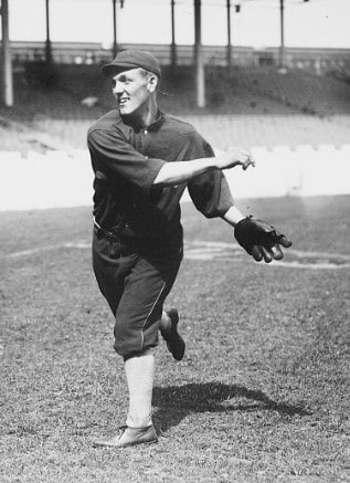 baseball player in dark uniform throwing the baseball