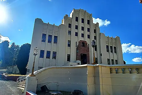 Sunlit view of the impressive white Art Deco Cochise County Courthouse against a clear blue sky in Bisbee. Big Jeep Tours.