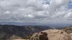 Rocky Juniper Flats summit with dramatic clouds and expansive mountain ranges in Cochise County.