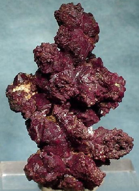 Rich deep red crystalline cluster of cuprite mineral with a sparkling texture. Bisbee Minerals.