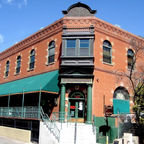 Historic red brick Stock Exchange Saloon and Brewery entrance with green columns white stairs and prominent BREWERY sign in Old Bisbee.