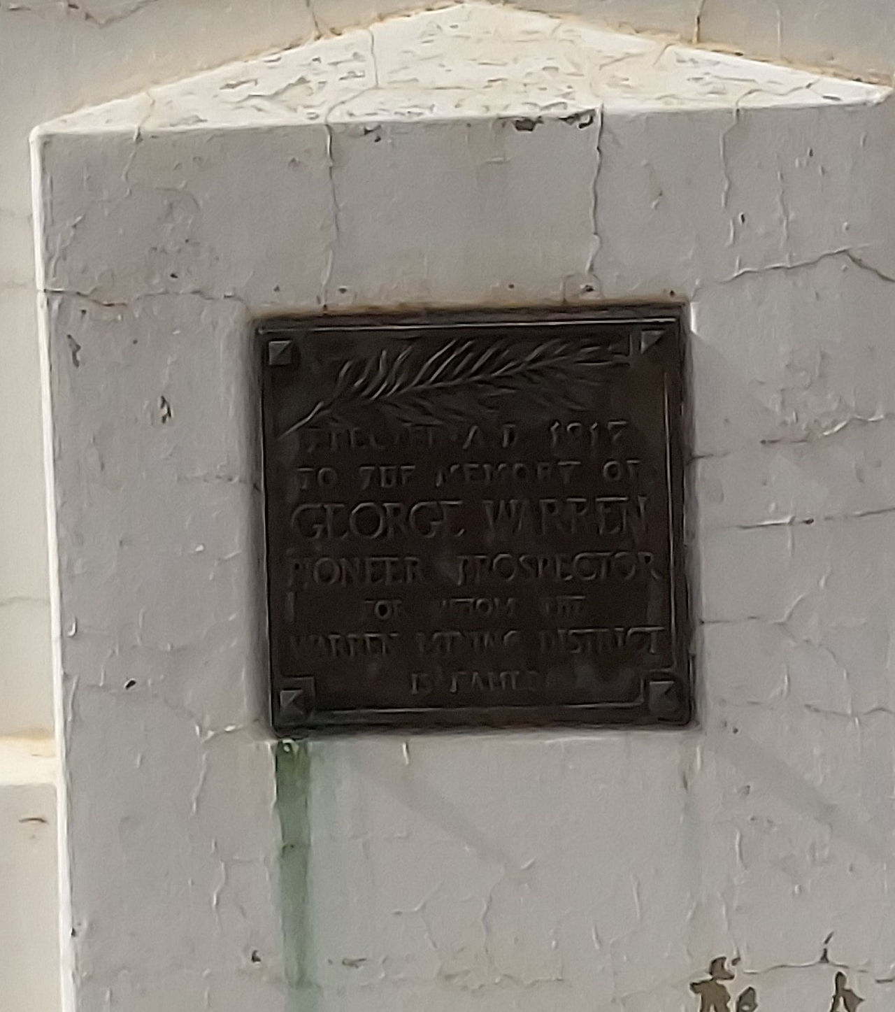 white headstone with bronze label