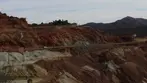 Colorful terraced walls of the Lavender Pit copper mine with Highway 80 running alongside under a blue sky near Bisbee.