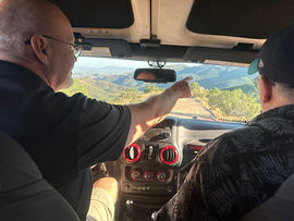 Tour guide pointing out mountain views through the windshield during a private Big Jeep Tours ride, part of the Juniper Flats Gallery in Bisbee, Arizona.
