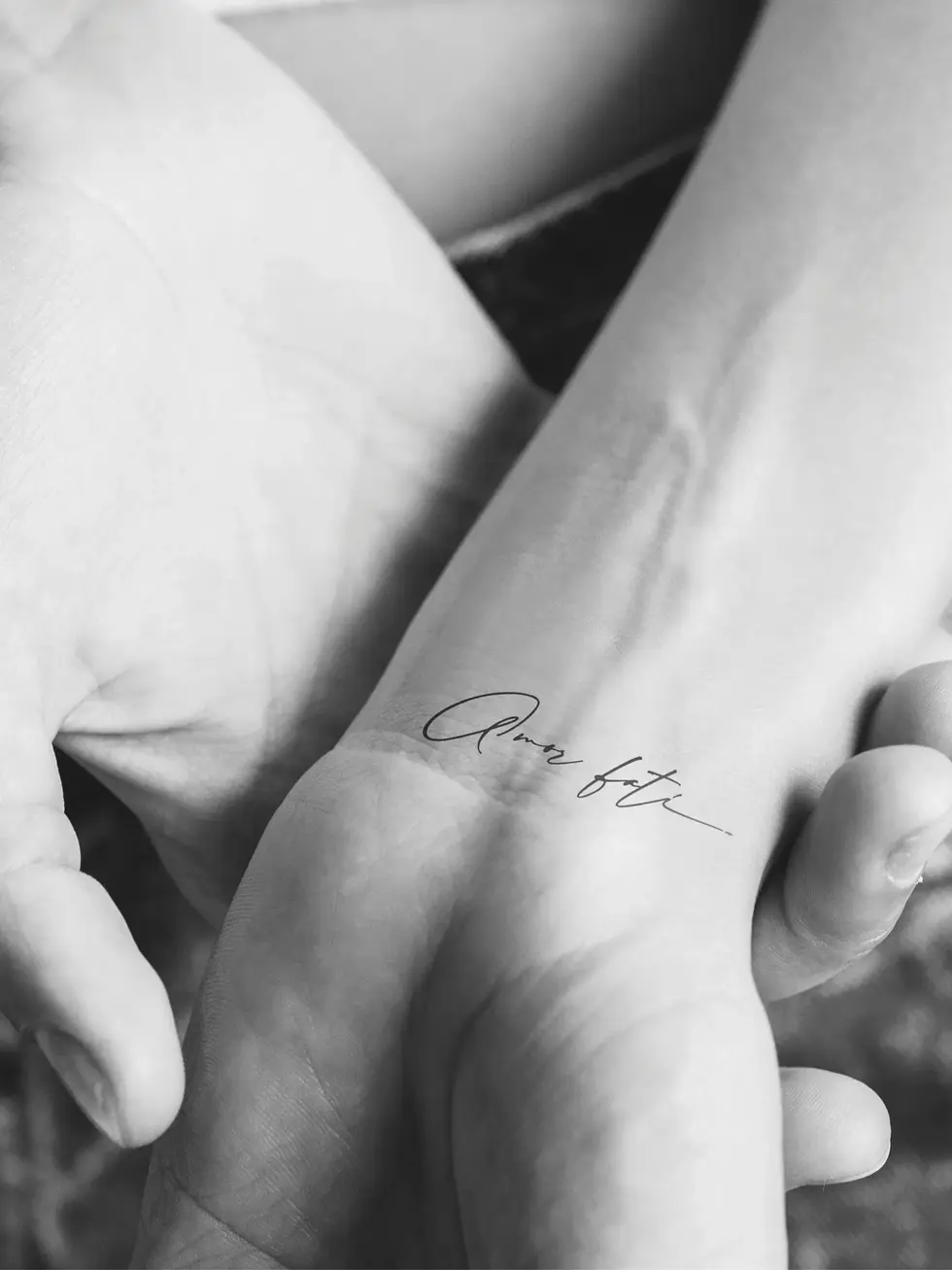 Fineline Tattoo „Amor Fati“ – inspirierender Schriftzug Tiny Tattoo Design.