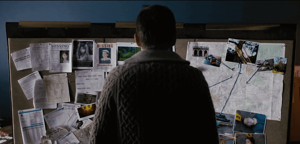 Ellison Oswalt (Ethan Hawke) in Sinister, looking at the board with murder clues and trying to decipher the killer, Bughuul