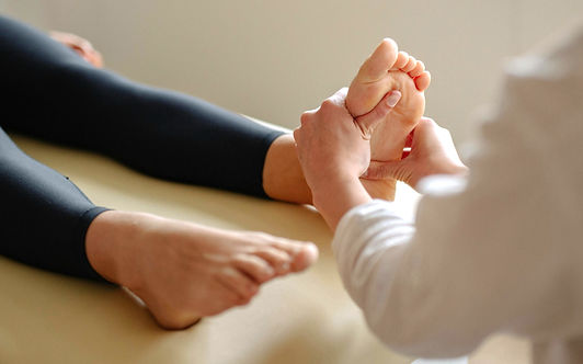 Chakra‑focused reflexology and Reiki session in Hamilton with practitioner pressing reflexology points on the client’s feet.