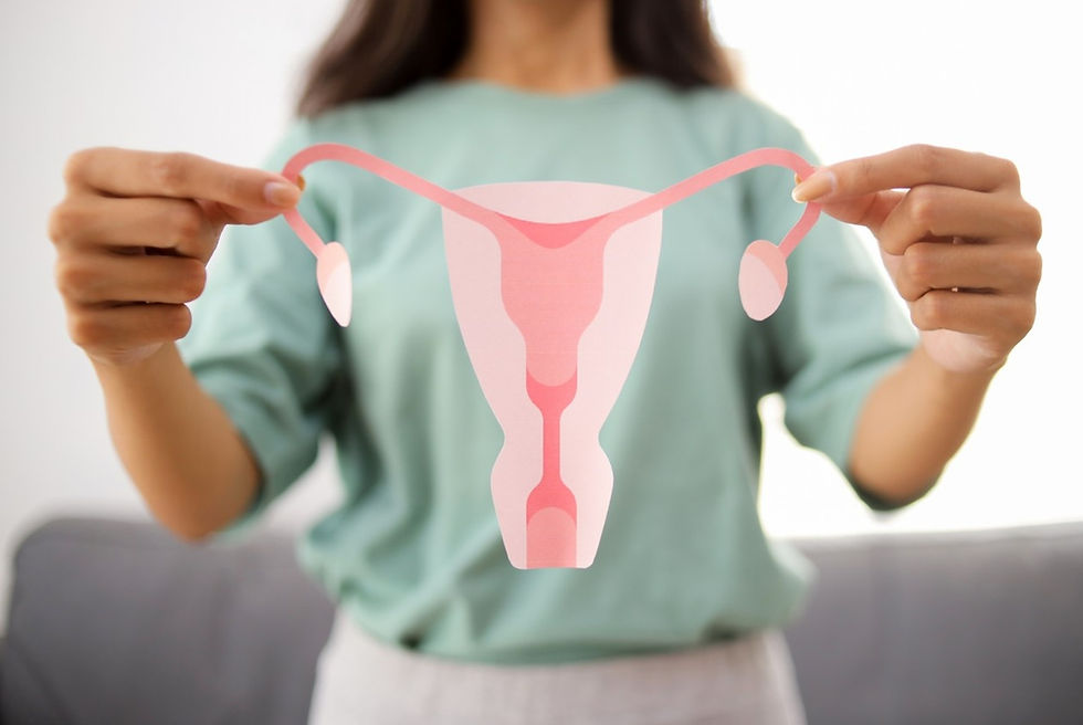 Woman holding a paper cut-out of a human uterus.