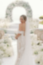 Bride in front of the altar with an arch of flowers