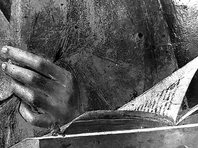 Hand on open book, black and white, detail shot