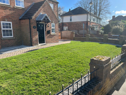 Brick house with green lawn and black door; Retford. Dk Landscapes Nottin
