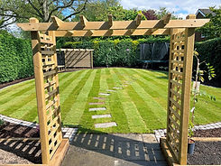 Wooden garden archway with a mowed lawn and stone path, Timber Structures, Dk Landscapes Nottin.