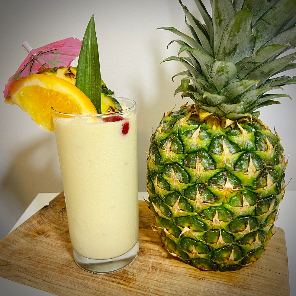 Pina colada cocktail with a pineapple, cherry and orange garnish and with a pink cocktail umbrella.