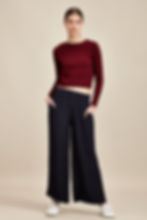 Woman in burgundy crop top and black wide-leg trousers