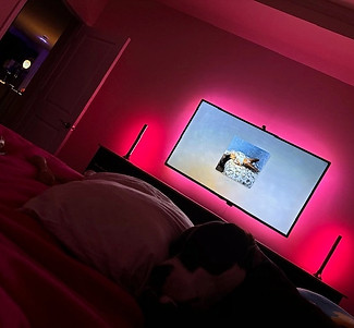 Professionally mounted TV with warm accent lighting.