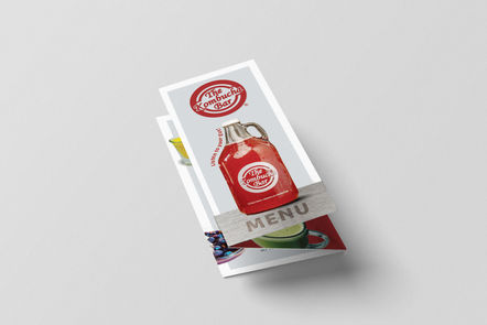 Kombucha Bar front cover tri-fold menu with the Kombucha Bar logo and red kombucha glass stout bottle sitting on a stainless steel table top.