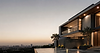 Modern luxury house overlooking a city at dusk