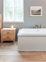 The Willow Room, a side view of the birthing suite highlighting the queen-size bed, natural lighting, and luxurious birthing tub.