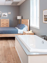 The Willow Room, an extended side view of the birthing suite highlighting the queen-size bed, natural lighting, and luxurious birthing tub.