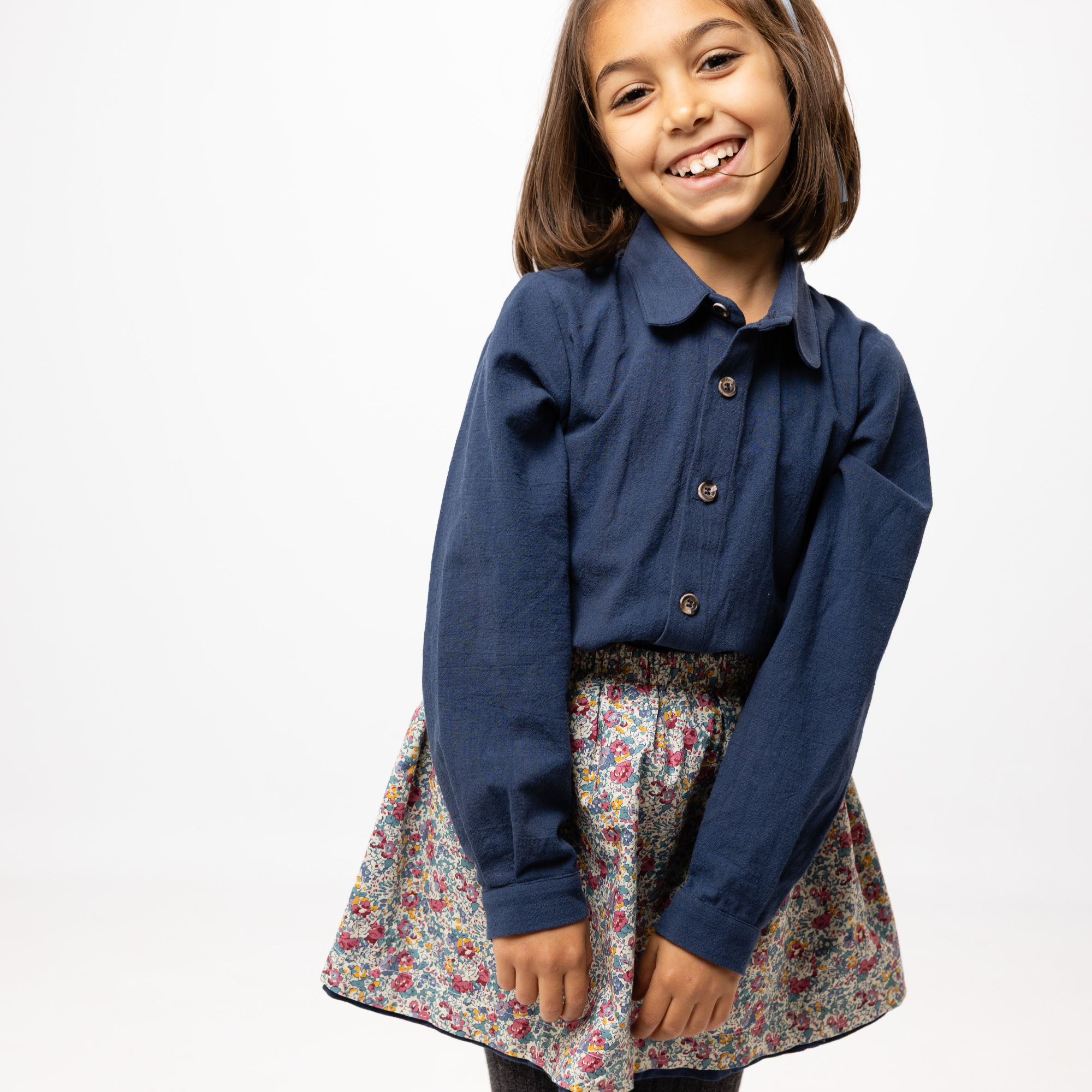 Girl wearing the Aikin Littles Ines Reversible skirt on the floral side