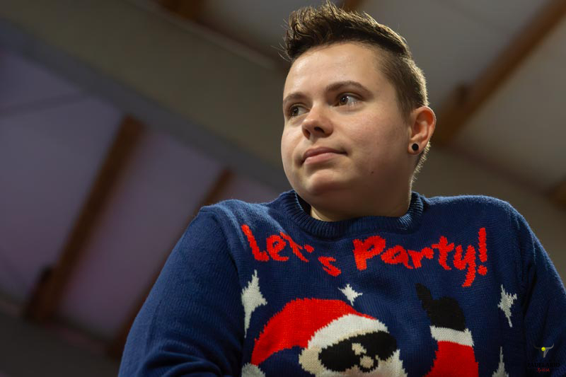 Junge Person trägt einen blauen Pullover mit „Let's Party!“-Schriftzug.