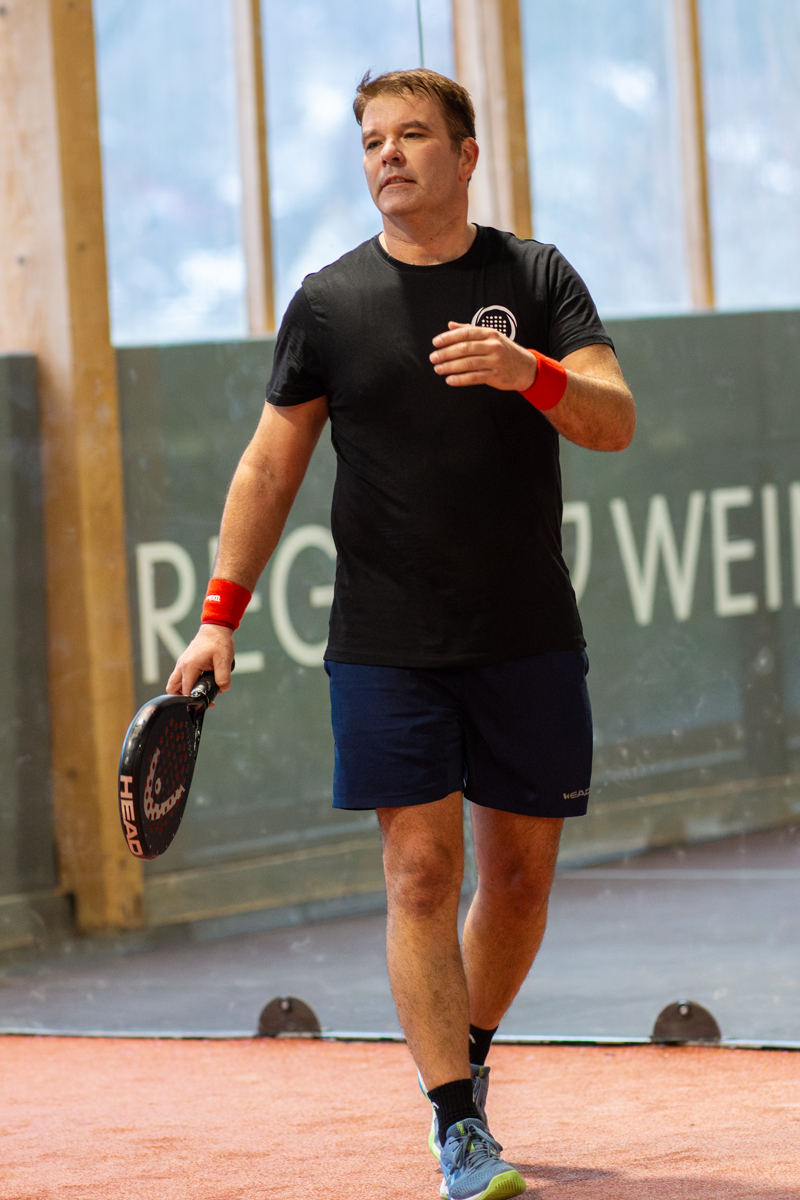 Mann mit Schläger beim Padel-Tennis, REG. WEIN in der Halle, Sportler