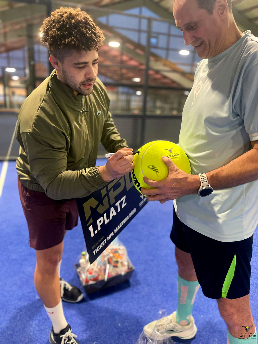 Mann signiert gelben Ball, "NP 1. PLATZ", nach Padel-Turnier im Sportpark.
