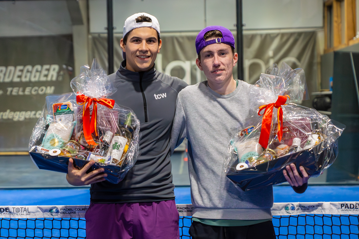 Zwei junge Männer präsentieren Geschenkkörbe mit Logo 