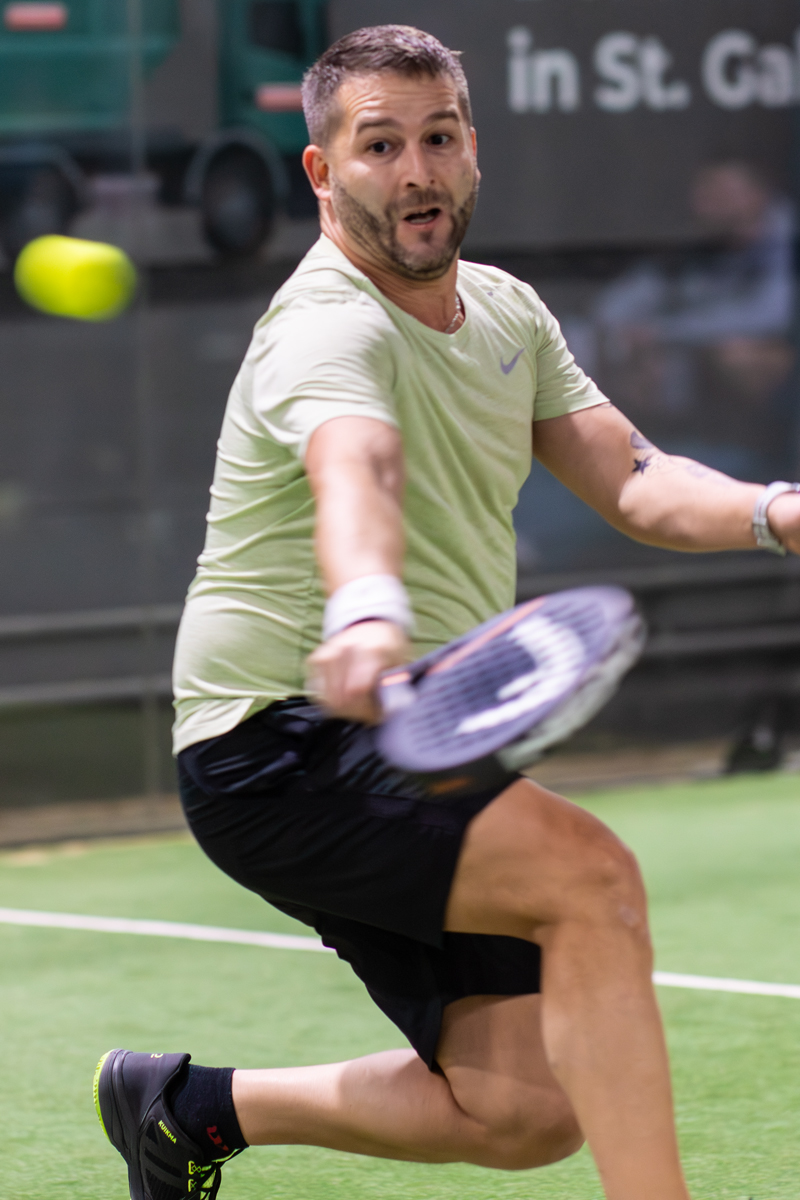 Mann spielt Padel Tennis, in St. Gallen stehend, schlägt Ball präzise. Sportart.
