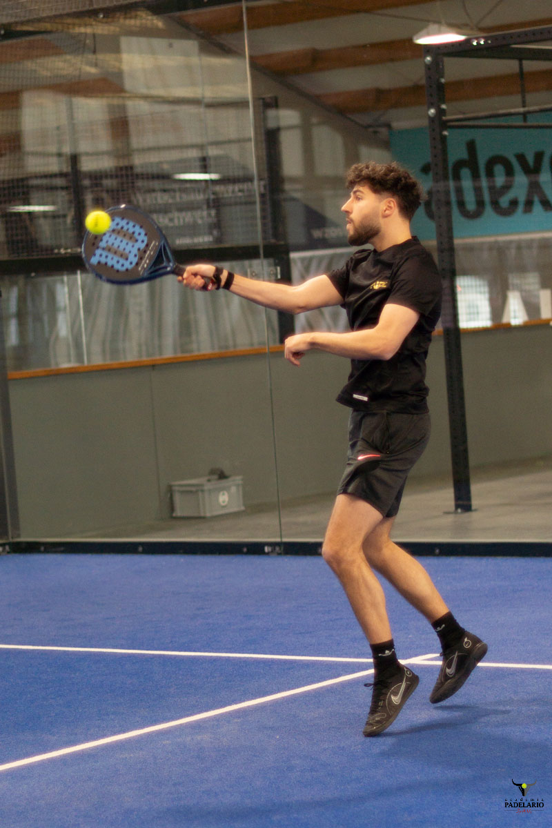 Junger Mann springt und schlägt den Ball. Padelspieler am Copa Padelario Turnier.