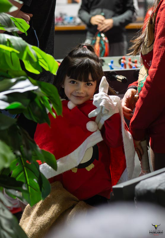 Ein lächelndes Kind im Weihnachtskostüm hält den Daumen hoch. Frohe Weihnachten!