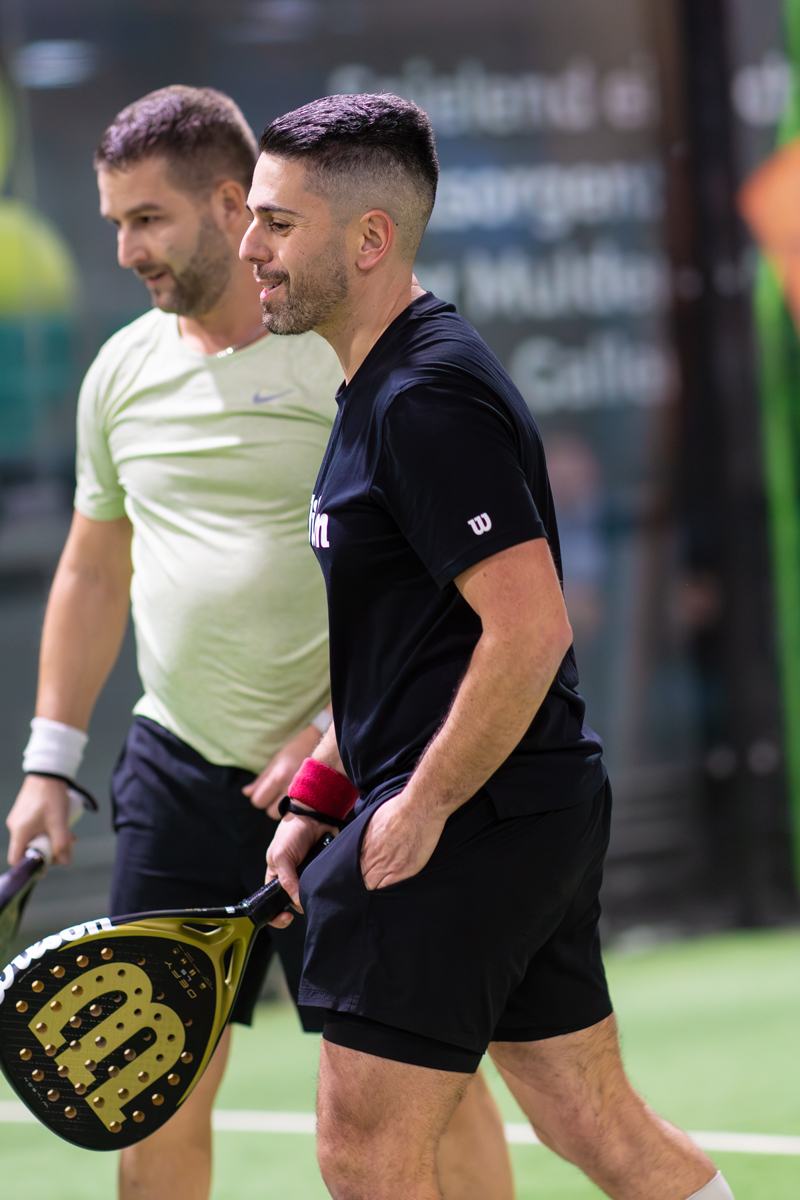 Zwei Männer stehen mit Tennisschlägern, bereit für ein Spiel, auf dem Platz.