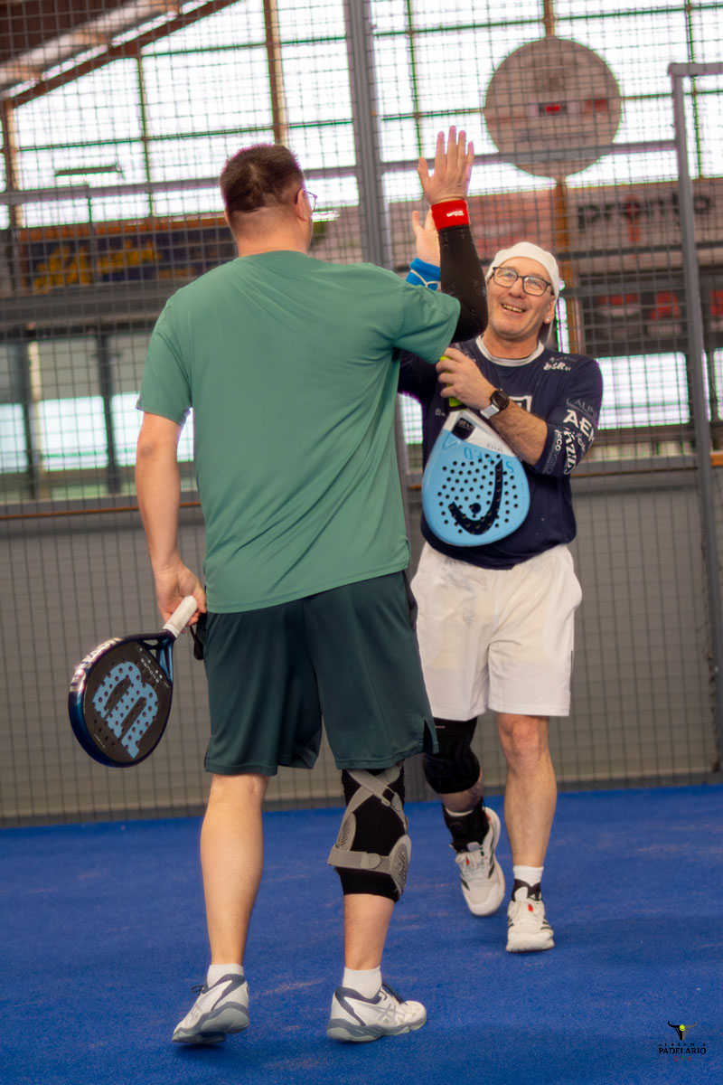 Zwei Padelspieler geben sich auf dem Indoor-Padel-Platz High-Five.