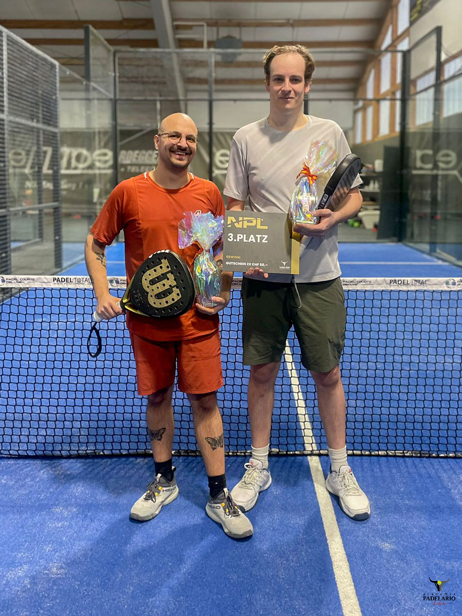 Zwei Männer mit PADEL 1. PLATZ Trophäe auf Padelplatz nach Sieg.