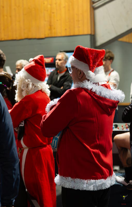 Zwei Weihnachtsmänner in roten Kostümen stehen in einem Raum. Americano Turnier 19-12-25