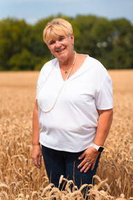 Femme souriante posant dans un champ de blé mûr. photographe