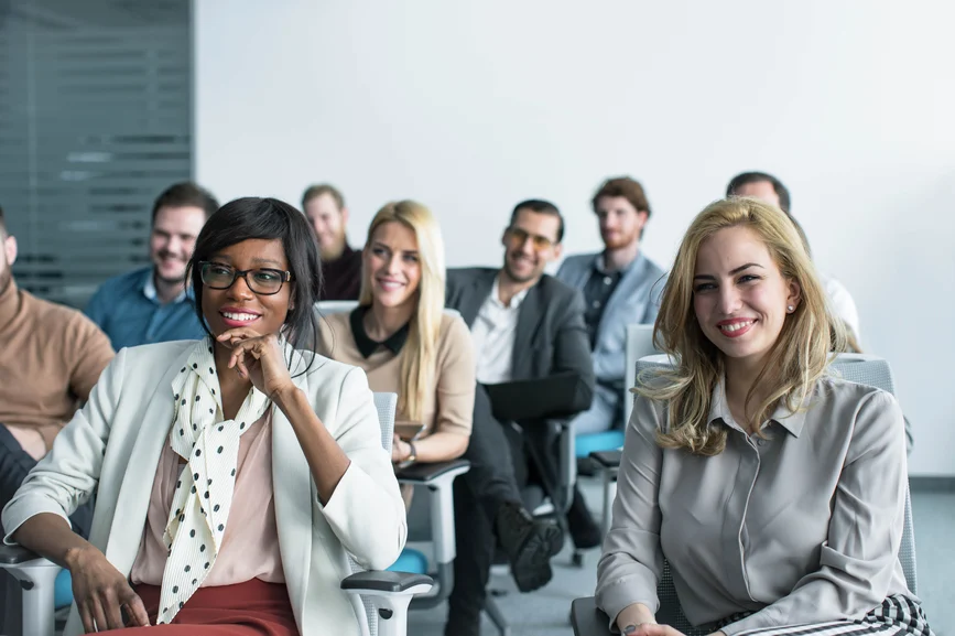 Pessoas sentadas recebendo treinamento