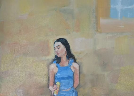 Portrait of Beautiful young girl in blue, leaning against yellow ochre wall. 