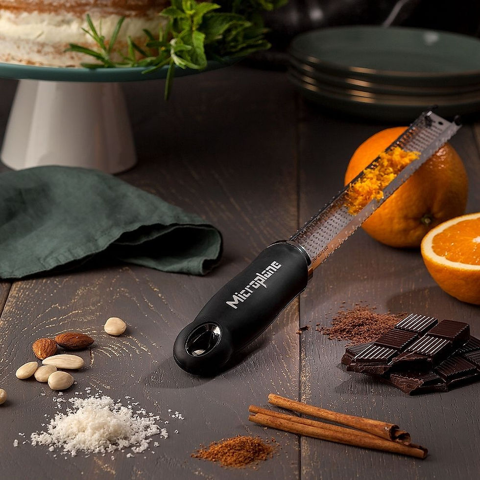 Miniaturbild: Microplane - Premium Zester-Reibe - schwarz, mit verschiedenen abgeriebenen Lebensmitteln.