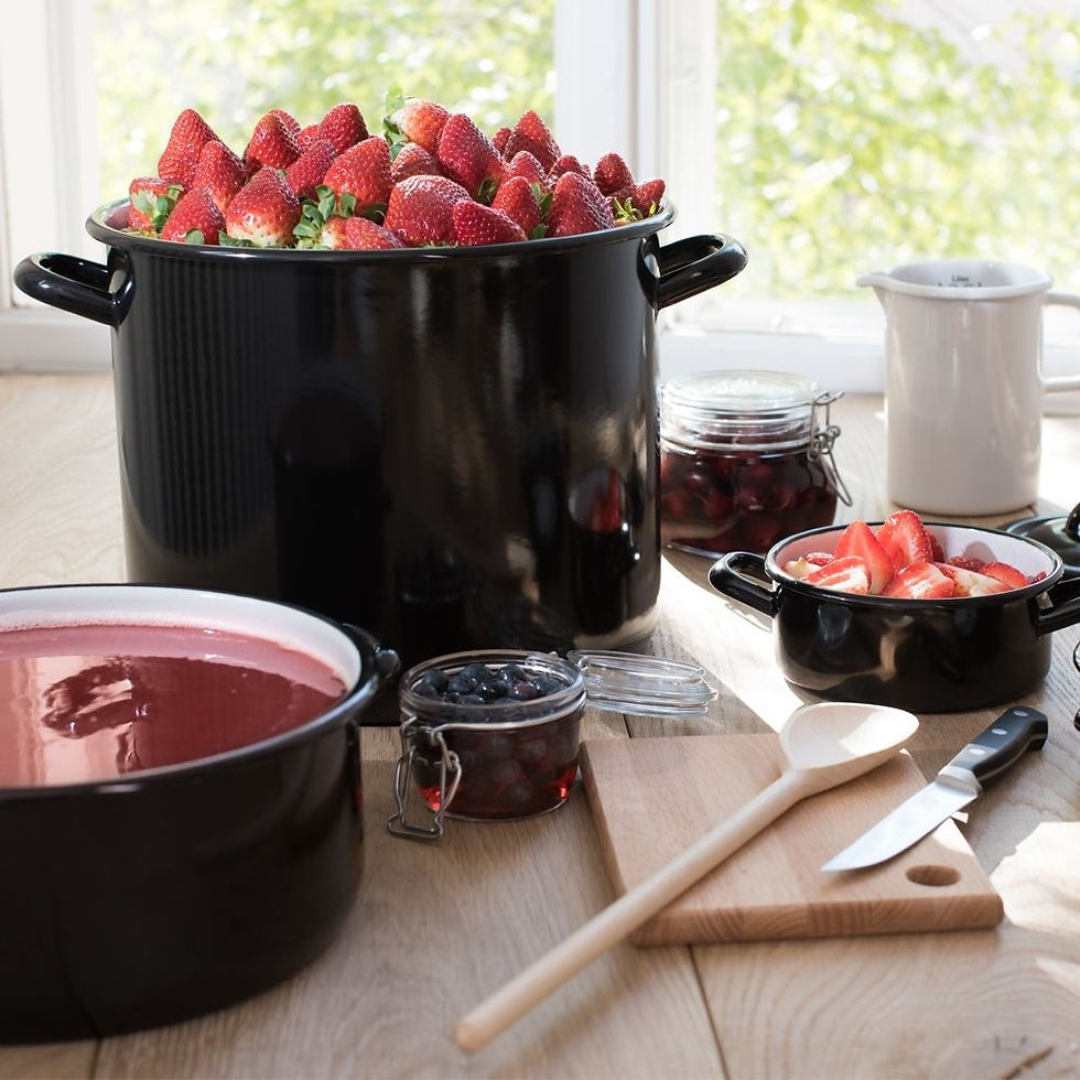 Miniaturbild: Großer schwarzer Topf, innen weiß, von der Marke Riess und zwei kleiner Töpfe, mit Erdbeeren auf einem Küchentisch.
