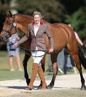 Ginny Howe walking beside a horse dressed smartly in show clothing